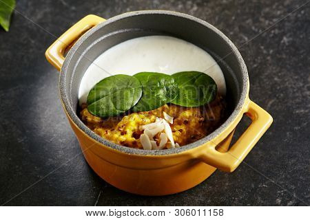 Exquisite Serving Restaurant Dish of Cooked Quinoa with Carrot Celeriac Cream and Ricotta Cheese. Italian Cuisine with Kinoa, Kinwa or Kinuwa Seeds on Black Marble Table