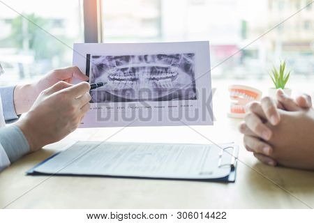 Dental Hygienist Demonstrating And Showing A Dummy Jaw To Chack-up Or Healing Teeth  Patient