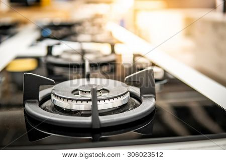 Modern Black Gas Stove On Countertop In Kitchen Showroom. Cooking Appliance In Domestic Kitchen. Hom
