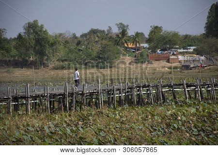 Thai People And Foreigner Travelers Travel And Walking Visit On Kae Dam Long Wood Bridge At Mahasara