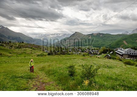 An Hiker Woman Is Looking At View Of Formigal - Spain. Formigal Town In Northern Spain
