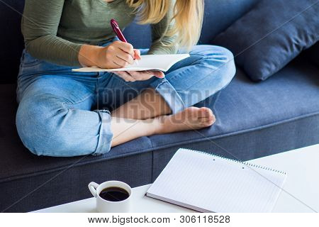Woman Writing On Couch At Home
