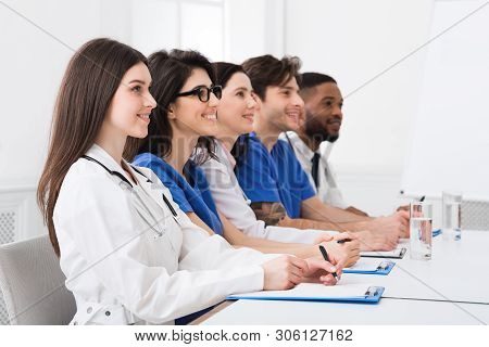 Medical Seminar. Doctors And Interns Listening To Professor In Conference Room