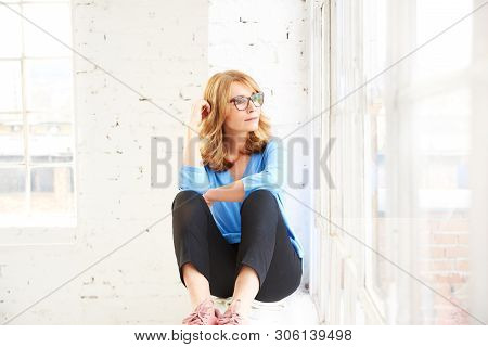 Thinking Beautiful Lady Looking Out The Window While Sitting And Realxing