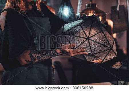 Talanted Young Designer With Tattoo On Her Hand Is Prepearing New Lamp, She Is Holdind It In Hands.