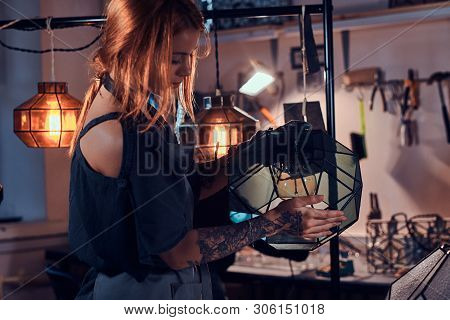 Talanted Young Designer With Tattoo On Her Hand Is Prepearing New Lamp, She Is Holdind It In Hands.