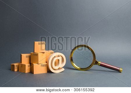 Pile Of Boxes With Email Symbol At And A Magnifying Glass. Concept Search For Goods And Services. Se