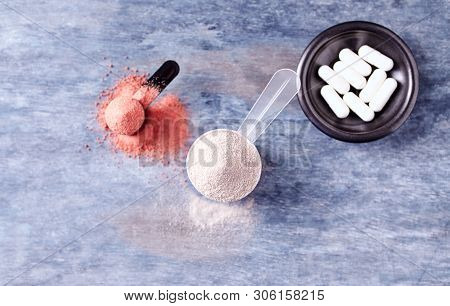 Scoop Of Whey Protein, Creatine Powder And Taurine Capsules. Sport Nutrition. Rustic Wooden Backgrou