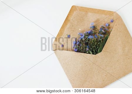 Little Cute Blue Forget-me-nots In A Kraft Paper Envelope, Selective Focus. Beautiful Bouquet Of Blu