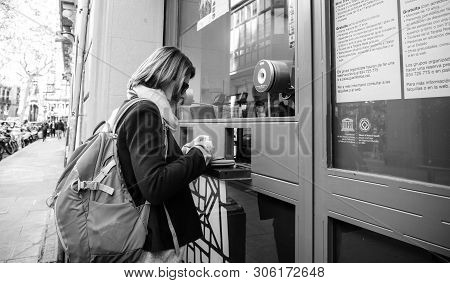 Barcelona, Spain - Nov 14, 2017: Black And White Image Of Street View Of Young Tourist Woman Buying 