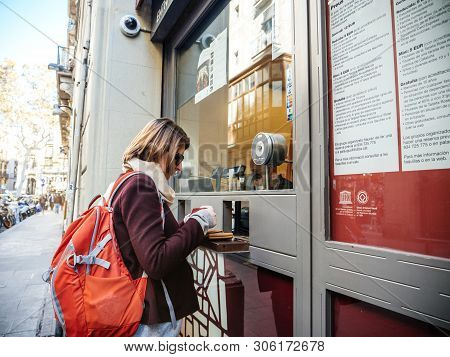 Barcelona, Spain - Nov 14, 2017: Street View Of Young Tourist Woman Buying Tickets At The Front Desk