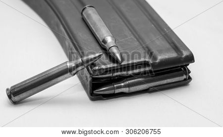 223 Caliber Bullets Loaded Into A Rifle Magazine With Two Additional Bullets Shot In Black And White