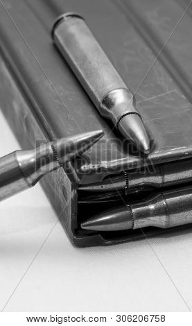 223 Caliber Bullets Loaded Into A Rifle Magazine With Two Additional Bullets Shot In Black And White