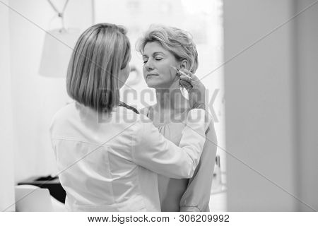 Black and White photo of 
Mature patient receiving reatment at hospital