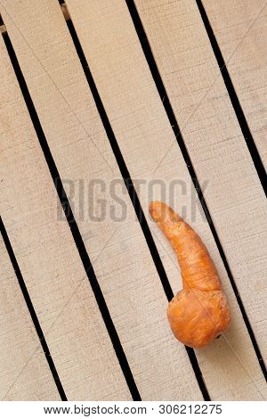 Ugly Carrot On Wooden Box Background. Organic Food, Unusual Deformed Fruits And Vegetables, Misshape
