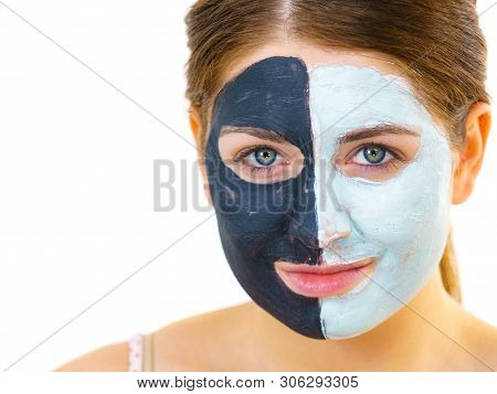 Woman With Clay Carbo Black Mask On Half Face And White Mud On Second Half. Girl Taking Care Of Oily