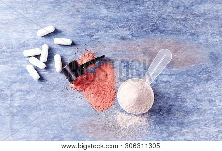 Creatine Powder, Scoop Of Whey Protein And Taurine Capsules. Sport Nutrition. Rustic Wooden Backgrou