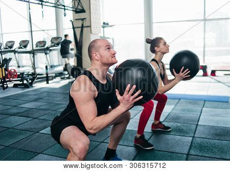 Сouple Functional Training. Sporty Man And Fit Woman Do Exercise With Medicine Ball In Gym
