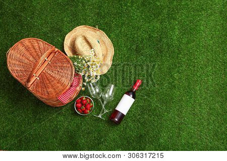 Flat Lay Composition With Picnic Basket, Wine And Strawberries On Grass, Space For Text