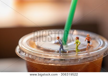 Sport And Drinking Concept. Group Of Miniature Figure Man And Woman Running On Top Of Cover Of Take 