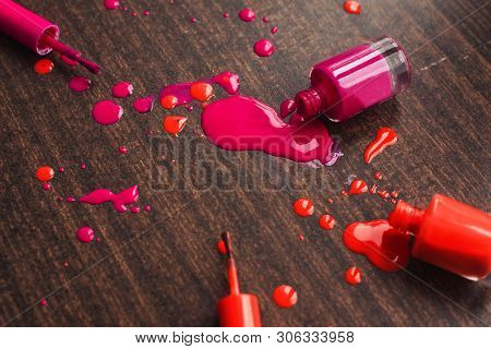 Spilled Orange And Pink Nail Polishes On Wooden Background. Nail Polish Drops. Blot Of Nail Polish O