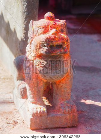 Mythological lion with vermillion red pigment powder guarding shrine at Kali Temple, worshiping Goddess Kali at Dhulikhel in Nepal