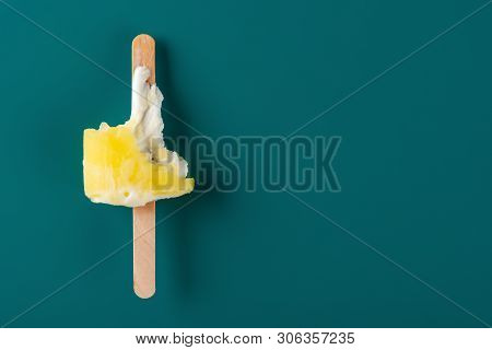 Yellow Popsicle Eaten With The Last Bit On A Green Background