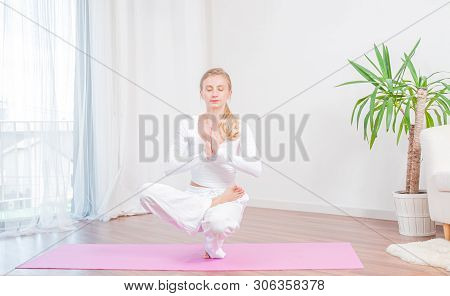 Beautiful Woman Is Practicing Yoga At Home On Yoga Mat, Girl Doing Half Lotus Toe Balance Exercise, 