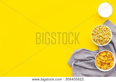 Cereals, Oatflakes And Cornflakes With Milk And Towel For Healthy Breakfast On Yellow Background Top