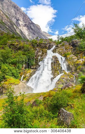 Melting Briksdal Glacier In Norway. Scenery Waterfall In Briksdal Glacier In Norway. Beautiful Water
