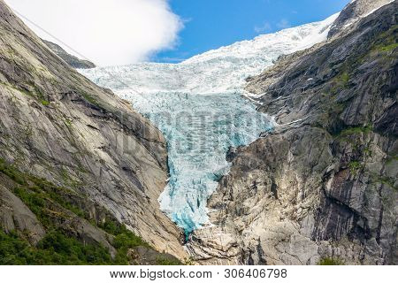 Briksdal Or Briksdalsbreen Glacier With Melting Blue Ice, Norway Nature Landmark And Its Lake Of Mil
