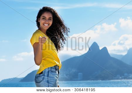 Beautiful Brazilian Woman With Curly Long Hair At Ipanema Beach At Rio De Janeiro With Beach In Summ