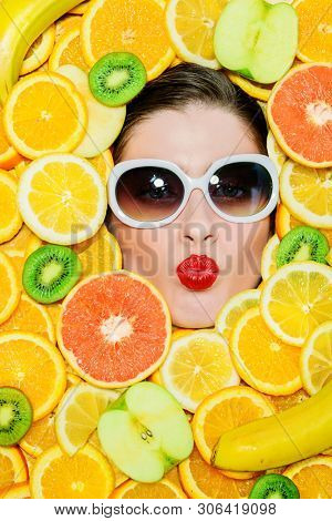 A portrait of a bright beautiful girl with juicy fruit posing in the studio over the yellow background. Beauty, health.