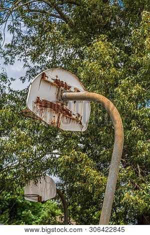 An Old Rusty Backstop In An Abandoned Basketball Court