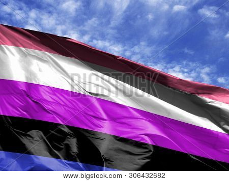 Waving Flag Of Genderfluid Close Up Against Blue Sky