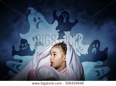 Excited Girl Hiding Under Blanket From Imaginary Ghosts. Scared Kid Sitting In His Bed At Home. Litt