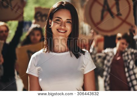 Portrait Of Young Positive Female Activist With Word Freedom Written On Her Face Looking At Camera A