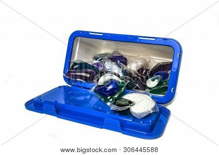 Capsules With Gel For Washing In A Plastic Container On A White Background Close-up