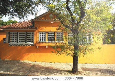 Old Yellow House Aith Beautiful Stylish Windows With White Woofen Frames And Roof Of Clay Tiles And 