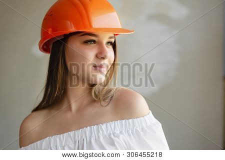 Sexy Girl Repairman In Construction Orange Helmet And White Shirt