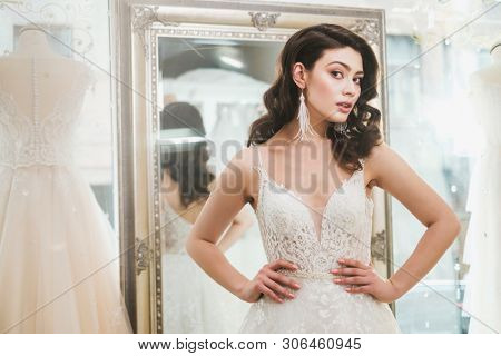 Beautifu bride choosing wedding dress in a wedding salon