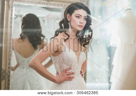 Beautifu bride choosing wedding dress in a wedding salon