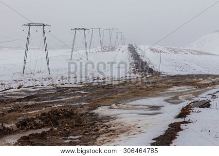 High Voltage Poles On A Snow-covered Hill, Mutnowskaya Power Station, Eastern Mountains. Jelizevo Di