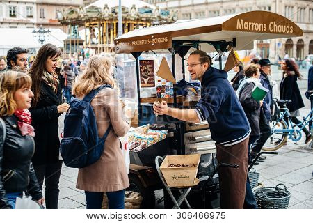 Strasbourg, France - Oct 28, 2017: Ambulant Male Seller Of Hot Chestnuts Marron Chauds On The Street
