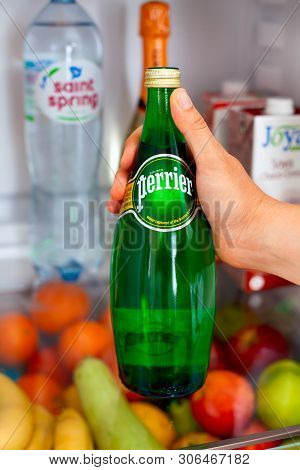 Tambov, Russian Federation - June 10, 2019 Woman Hand Taking Out Bottle With Perrier Water From Frid