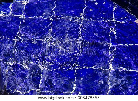 Fountain Ripple Splash. Clear Water, Splashes, Bubbles Over Deep Blue Tile Background.  Ripples In W