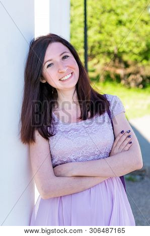 Beaytiful Cheerful Caucasian Woman In A Purple Summer Dress Standing Outside In The Park
