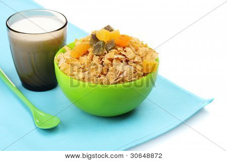 leckere Cornflakes in grüne Schüssel und Glas Milch, isoliert auf weiss