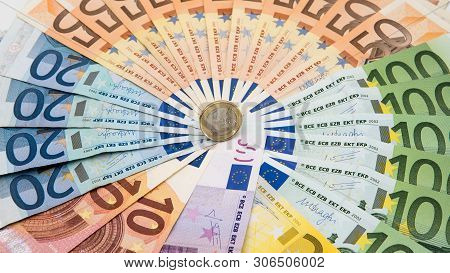 Closeup Of A Coin One Euro With Banknotes Of Different Values. Cash Money