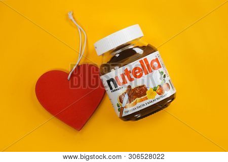 Kyiv, Ukraine - May 27, 2019: Nutella introduced to the market in 1964 by Italian company Ferrero. Nutella hazelnut on yellow background